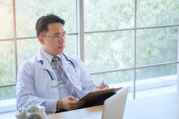 Doctor with Stethoscope working writing on paperwork 