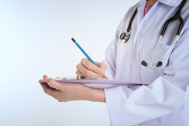 Doctor with Stethoscope working writing on paperwork 