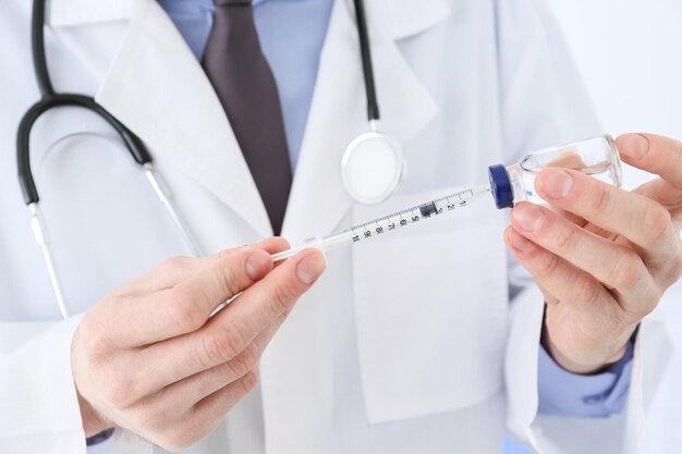 Doctor with syringe and medicine for vaccination closeup