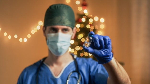 クリスマスの背景にワクチンを持つ医師