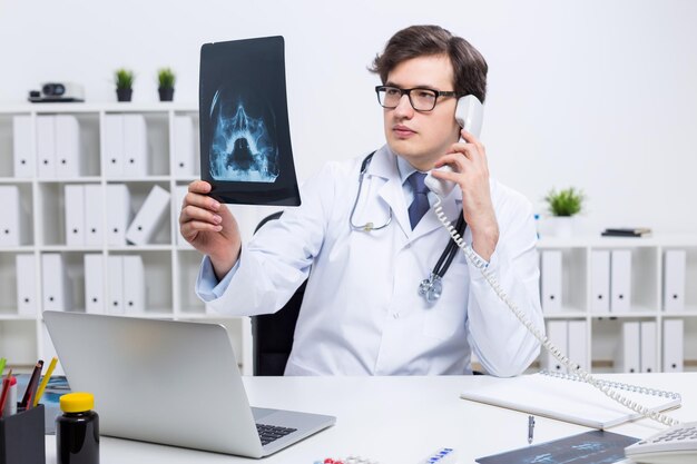 Doctor with xray on phone