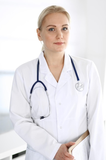 Doctor woman adult standing straight in hospital office, portrait. Perfect medical service in clinic. Medicine and healthcare concepts.