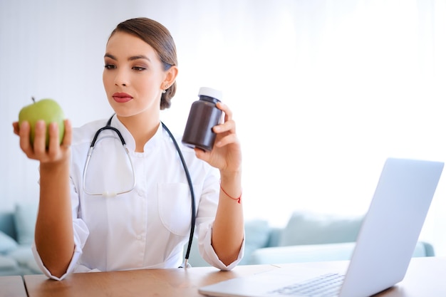 Photo doctor woman advising apple instead of pills healthy food