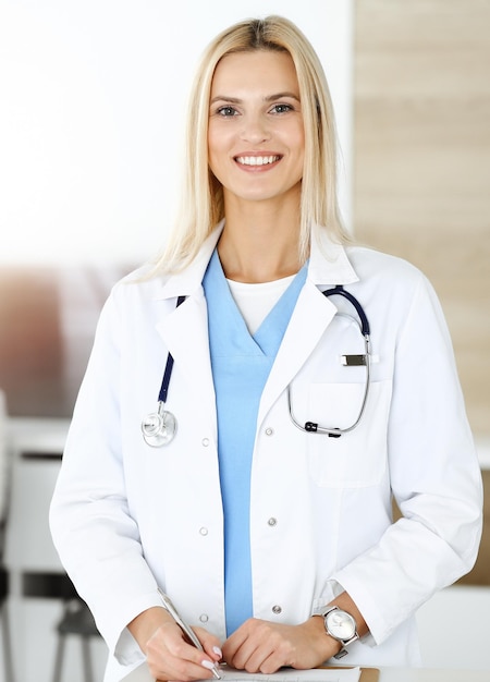 Doctor woman controls medication history records and exam results while using clipboard in sunny hospital Medicine and healthcare concept