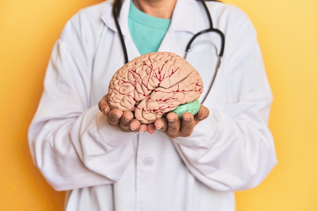 Doctor woman holding a brain model against blue