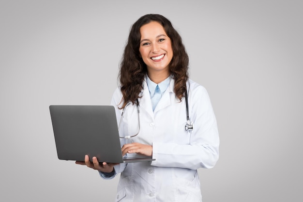 Photo doctor woman holding laptop with pleasant smile