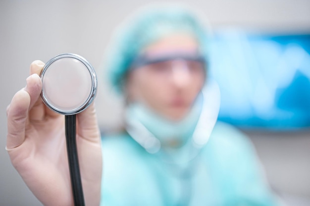 doctor woman in the hospital listens to the patient with a stethoscope