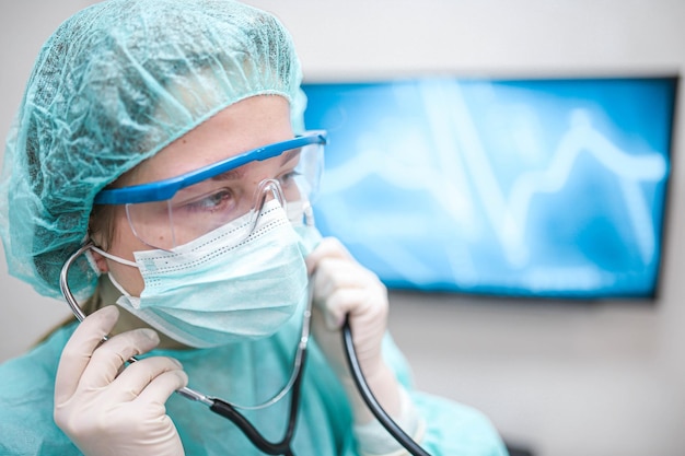 doctor woman in the hospital listens to the patient with a stethoscope