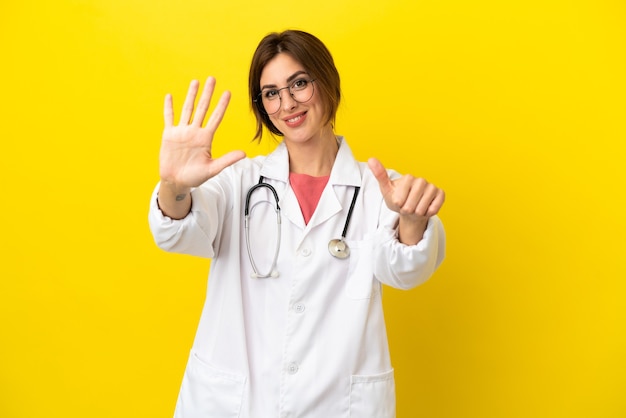 Doctor woman isolated on yellow background counting six with fingers