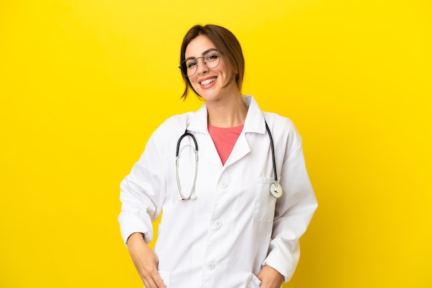 Doctor woman isolated on yellow background laughing