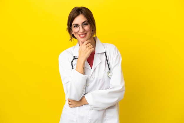 Doctor woman isolated on yellow background with glasses and smiling