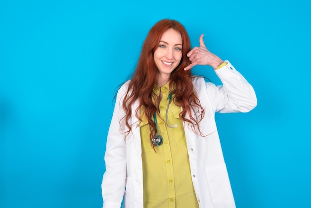 Doctor woman makes phone gesture says call me back again has glad expression