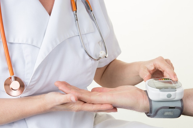 Doctor woman measuring arterial blood pressure