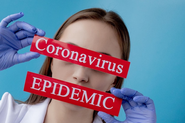 Doctor woman pointing to red paper with mesaage Coronavirus on blue background World Health Organization WHO introduced new official name for Coronavirus disease named COVID19