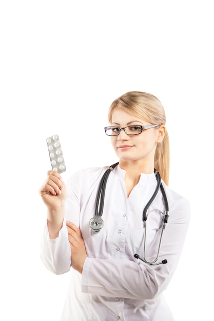 Женщина-врач показывает таблетку Молодая женщина-медик на белом фоне
