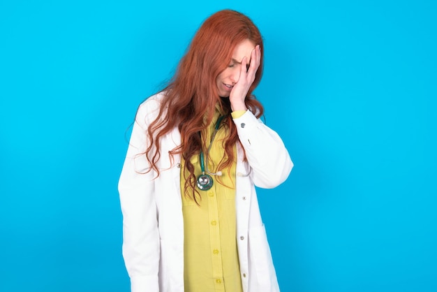 Photo doctor woman with sad expression covering face with hands while crying depression concept