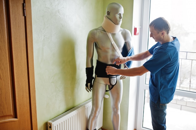 Doctor worker works with mannequin cast on arm and neck at prosthetist clinic.