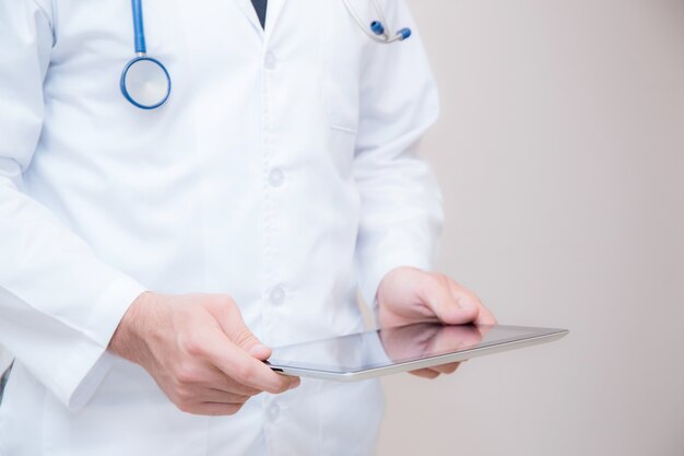 Doctor working on a digital tablet on white background.