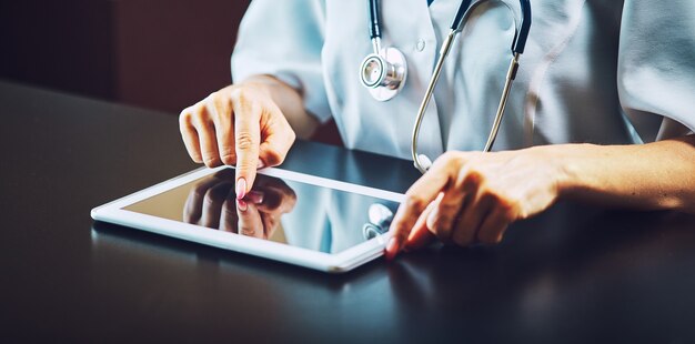 Doctor working on a digital tablet with copy space