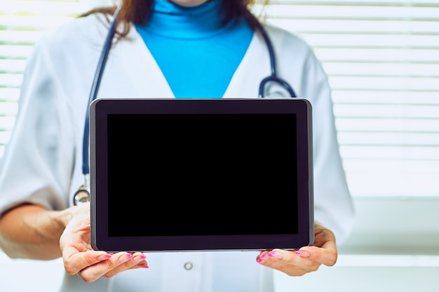 Doctor working on a digital tablet with copy space