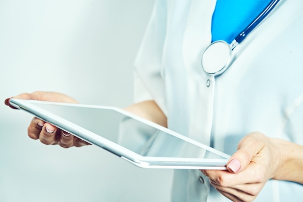 Doctor working on a digital tablet with copy space