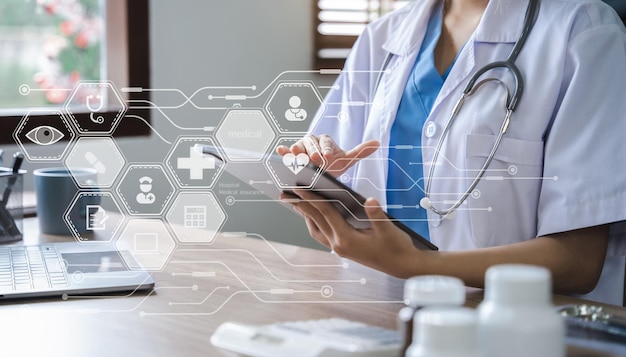 Photo doctor working on laptop computer and tablet and medical stethoscope on clipboard on desk