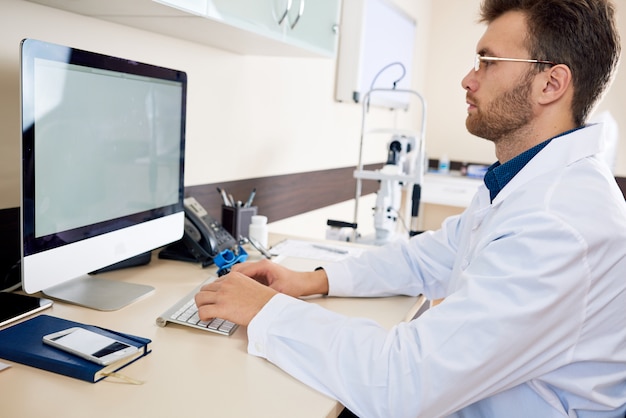 Doctor Working with Computer in Office