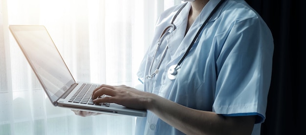 Doctor working with laptop computer in medical workspace office doctor working on laptop computer in modern clinics office search medical information banner copy space