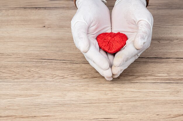 The doctor wrapped his hand around the red heart on the desk