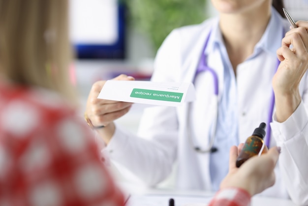 Photo doctor writes the patient prescription for marijuana. cannabinoids in medicine concept