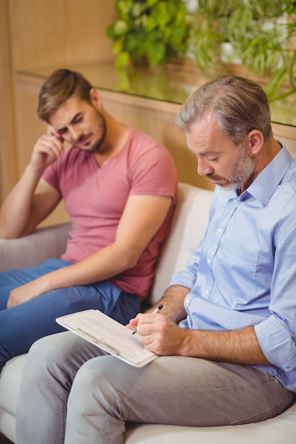 Medico che scrive negli appunti durante la consultazione del paziente