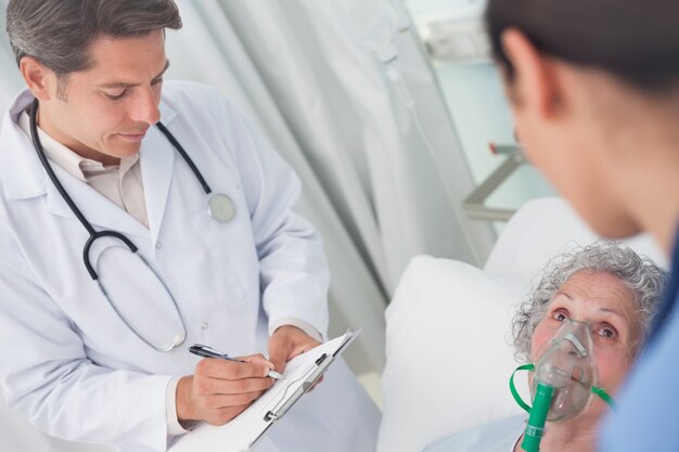 Doctor writing on a clipboard with a pen