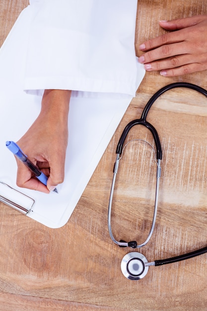 Doctor writing on clipboard 