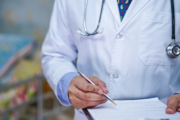 Doctor writing down the diagnosis on clipboard.