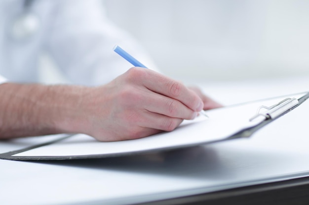 Photo doctor writing out the prescriptioncloseup