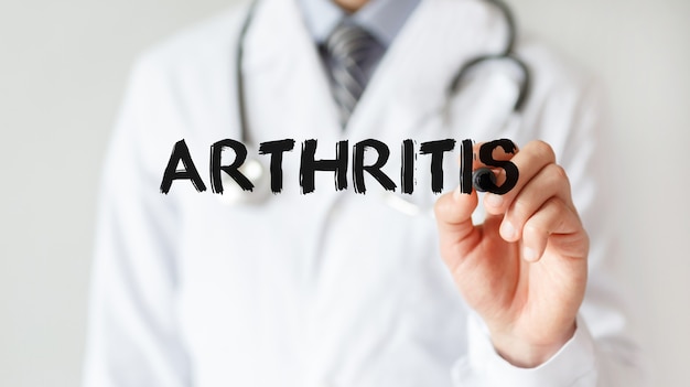 Doctor writing word Arthritis with marker, Medical concept