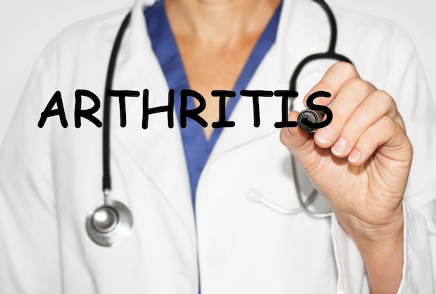 Doctor writing word Arthritis with marker