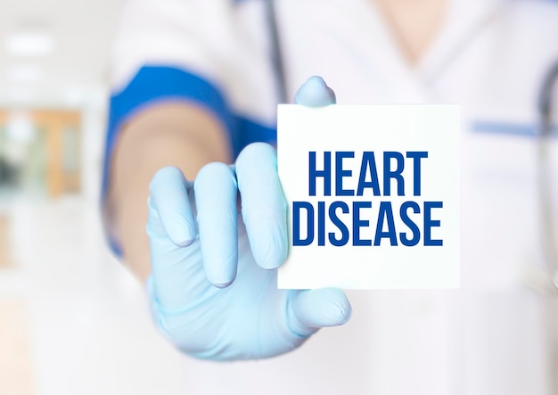 Doctor writing word HEART DISEASE with notepad Medical concept