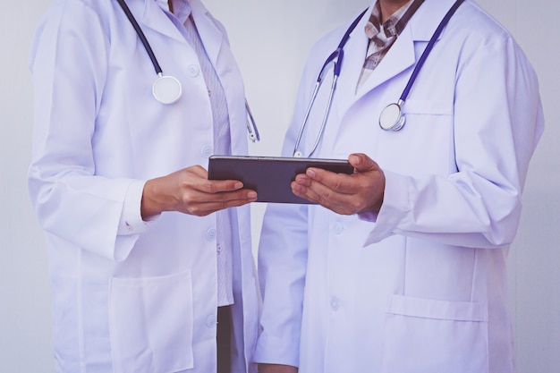 Doctors checking patient information on a tablet device