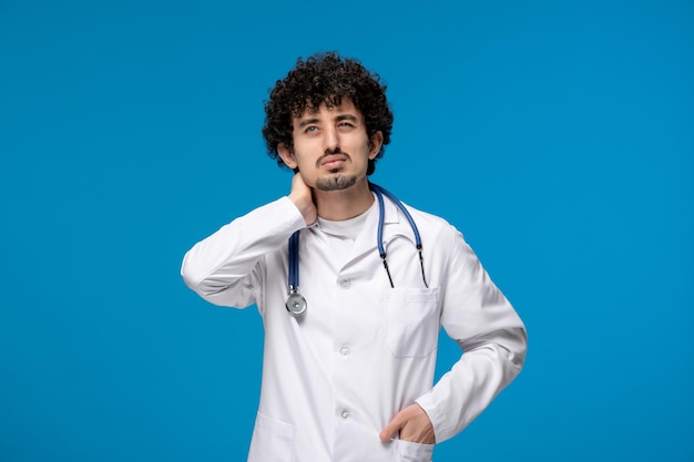 Doctors day curly brunette cute guy in lab coat thinking and looking up