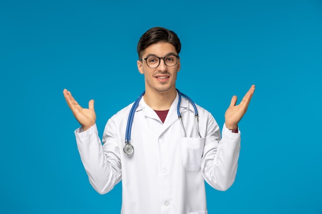 Doctors day cute young brunette guy in lab coat wearing glasses waving hands