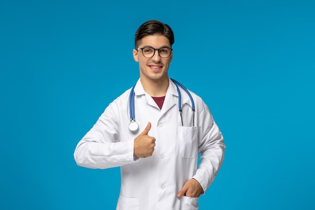 Doctors day handsome brunette cute guy in medical gown showing good gesture