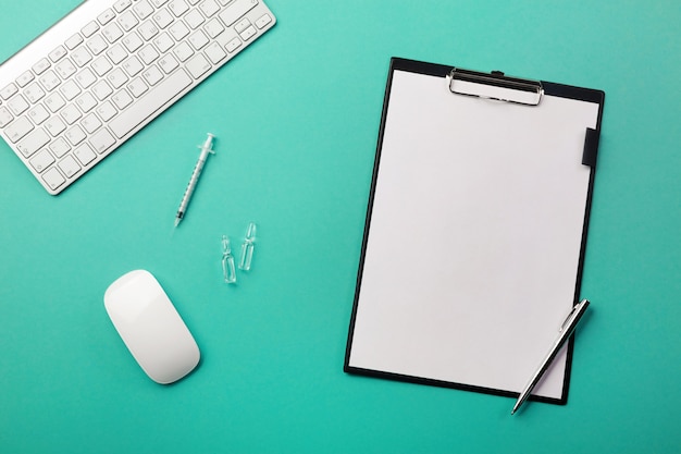 Doctors desk with tablet, pen, keyboard, syringe and ampoules