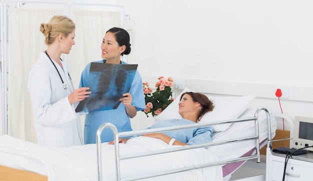 Doctors examining x-ray with patient in hospital