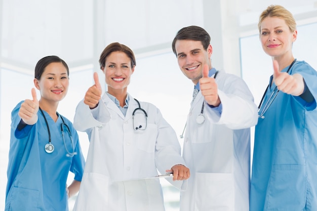 Doctors gesturing thumbs up at hospital