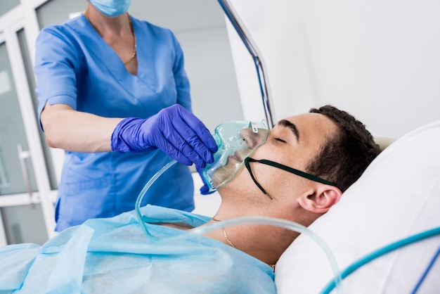 Doctors give resuscitation to a male patient in the emergency room. Cardiac massage