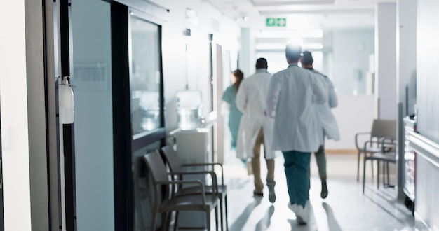 Doctors group and running in corridor for emergency surgery and healthcare work in hospital Medical teamwork men and women with call in hallway for wellness care and support with back in clinic