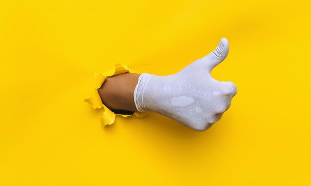 Doctors hands in medical gloves in shape of heart on blue background