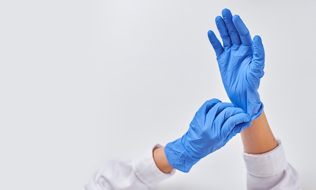 Doctors hands in medical gloves in shape of heart on blue background