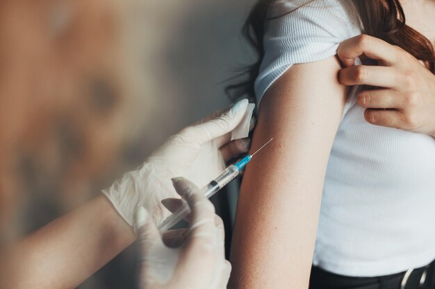 의사들은 환자 코로나 바이러스 예방 의료 기관의 팔에 코비드 백신을 넣는 손을...